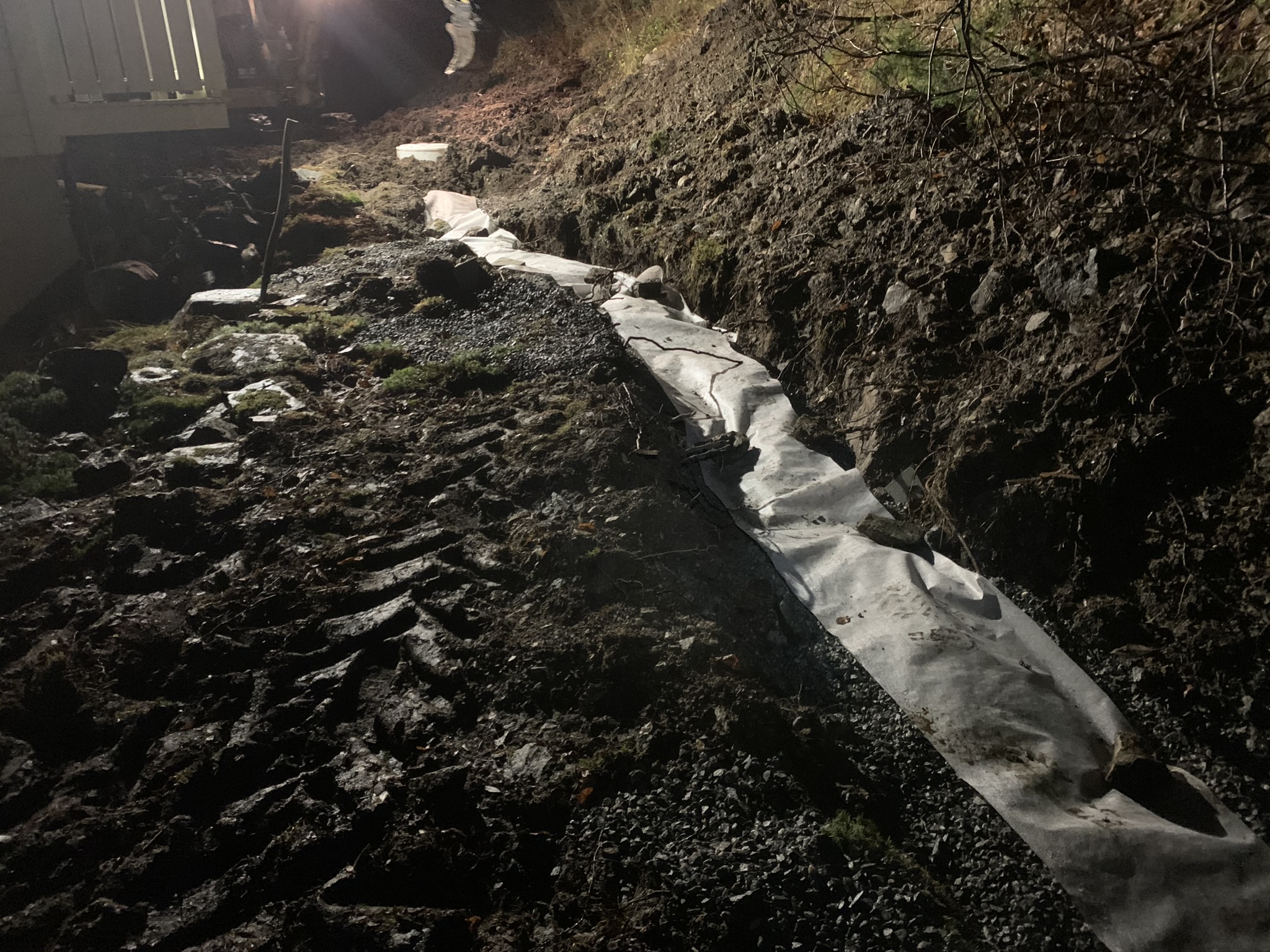 Grøft om natten — rørlegging med geotekstil og grus på plass