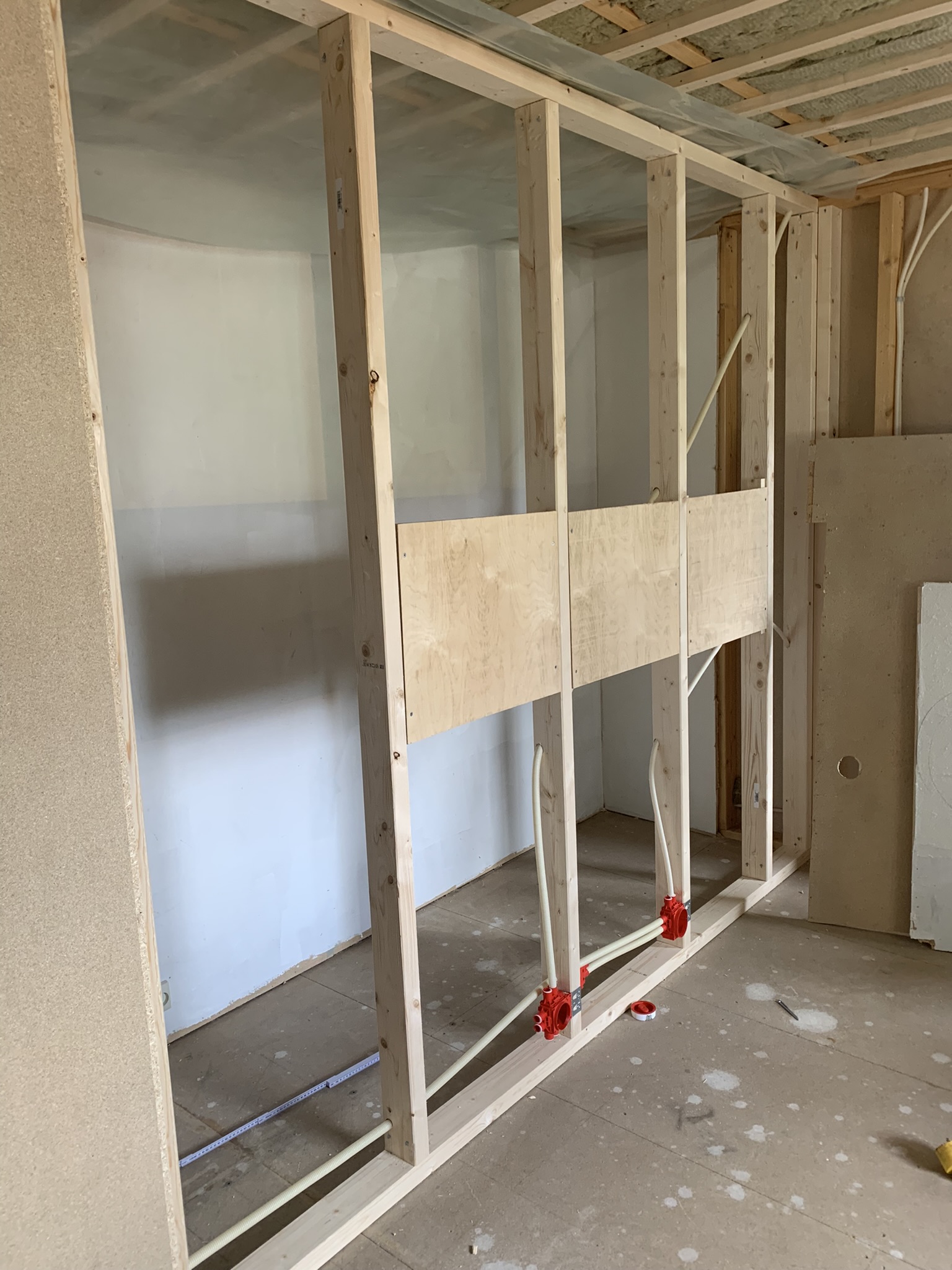 Bergvarmerør med røde fittinger inne i veggboksen