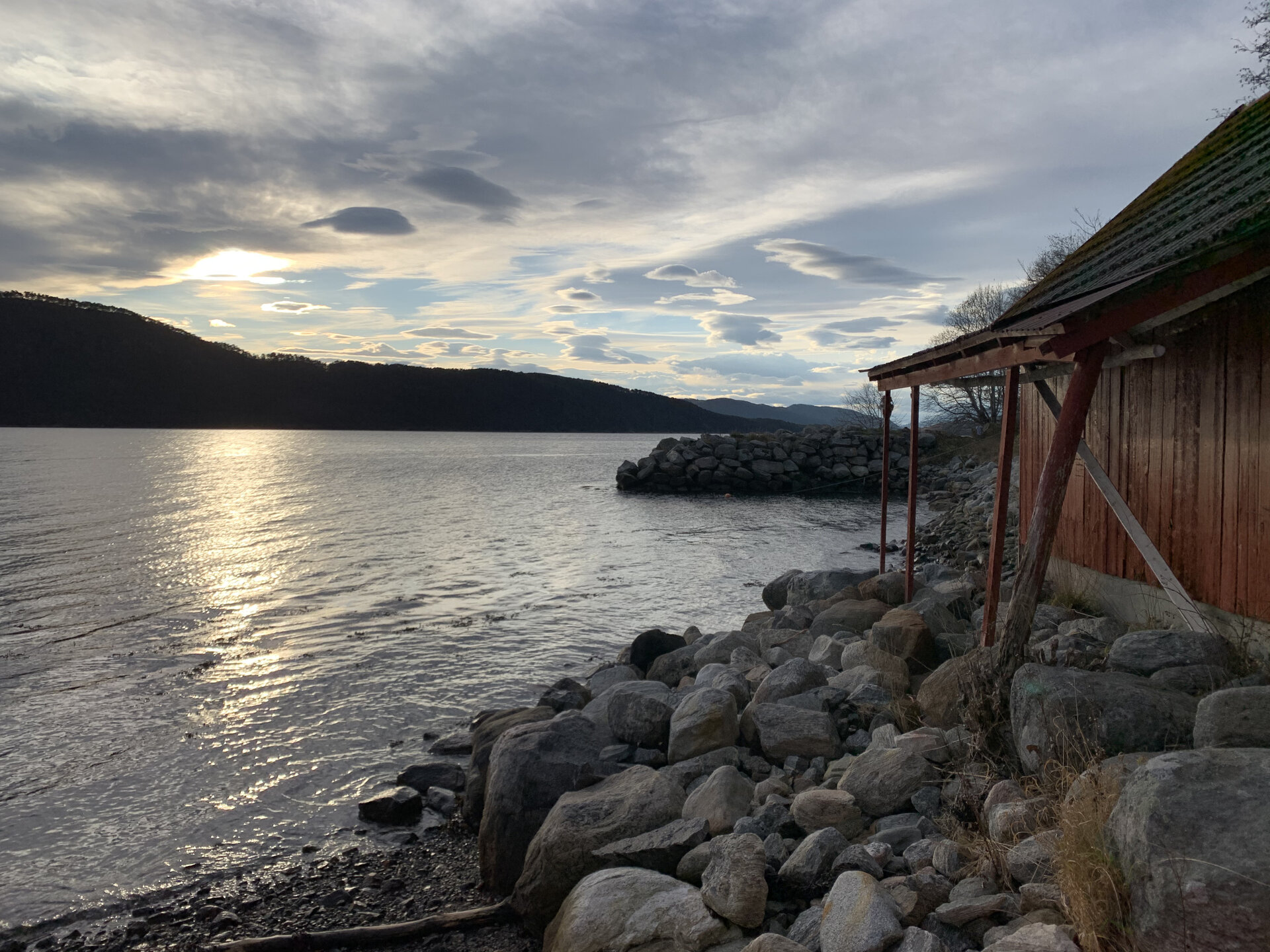 Solnedgang over fjorden ved naustene